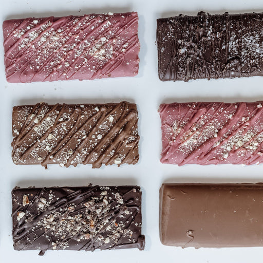 Gourmet toffee bars with different toppings arranged in a grid on a white background