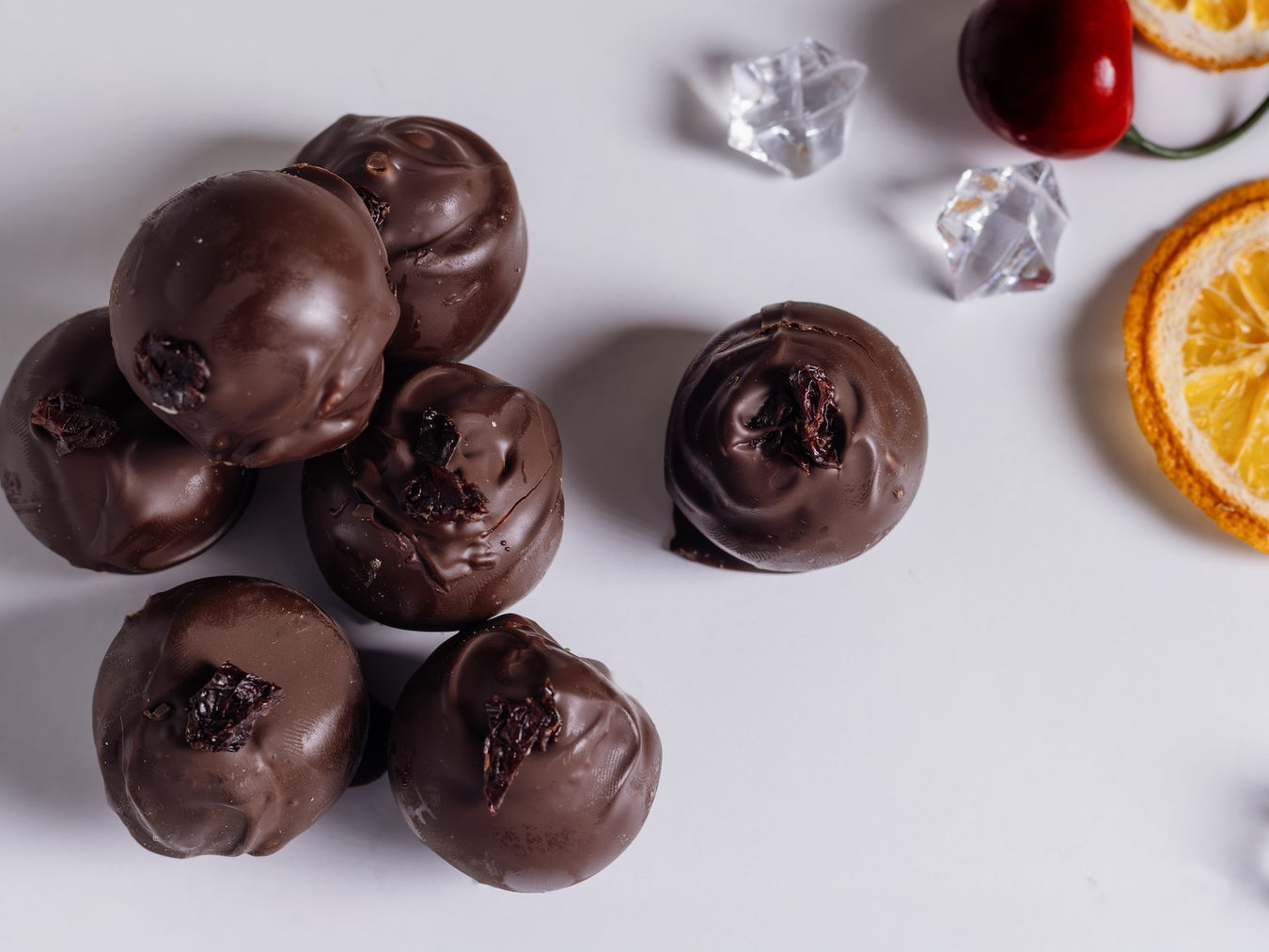 Brandy Old Fashioned truffles on a white surface with decorative elements.