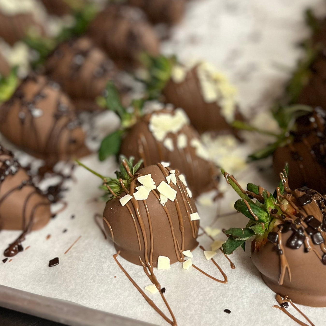 Chocolate-dipped strawberries on a white plate with a blurred background