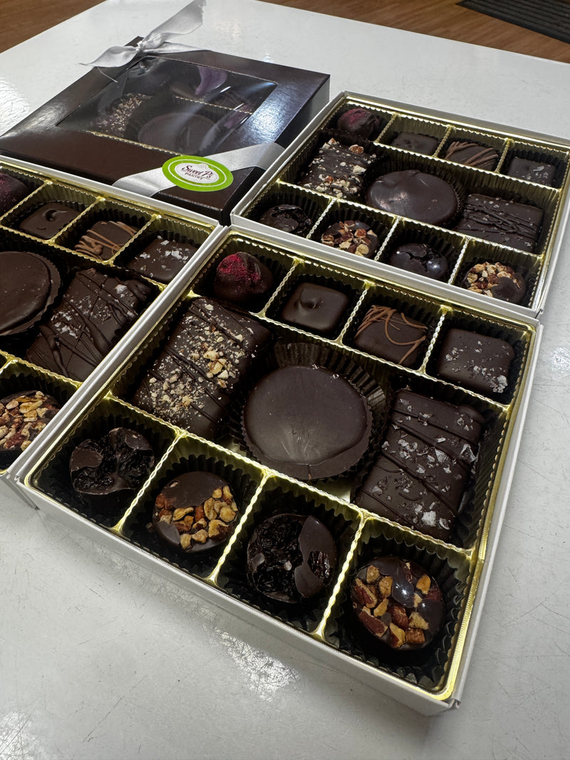 Box of assorted chocolates including Peanut Butter Cup, Toffee Bites, Seasonal Truffles, Nut and Fruit Clusters.