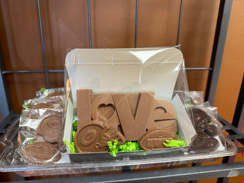 Box of chocolates featuring 3 items: 3 oz Love Bar, Packers Helmet Chocolate and Packers Football. 