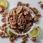 Pecans in a glass surrounded by slices of lime