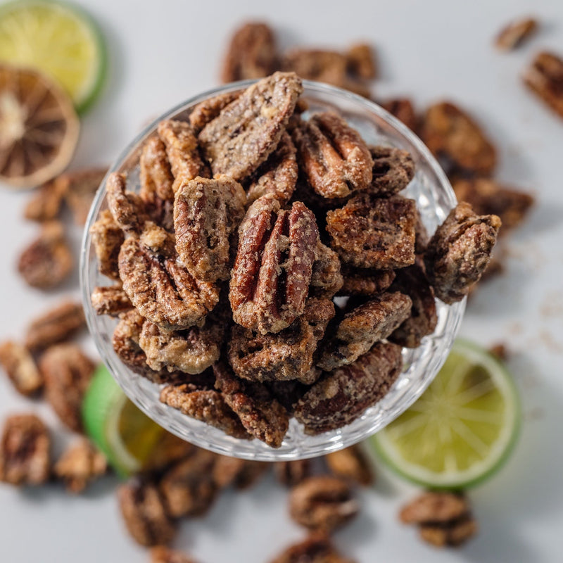 Pecans in a glass surrounded by slices of lime