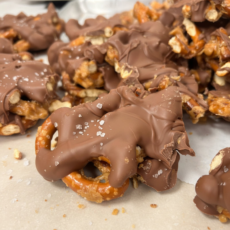 Close-up of chocolate-covered pretzel snack mix on a white surface