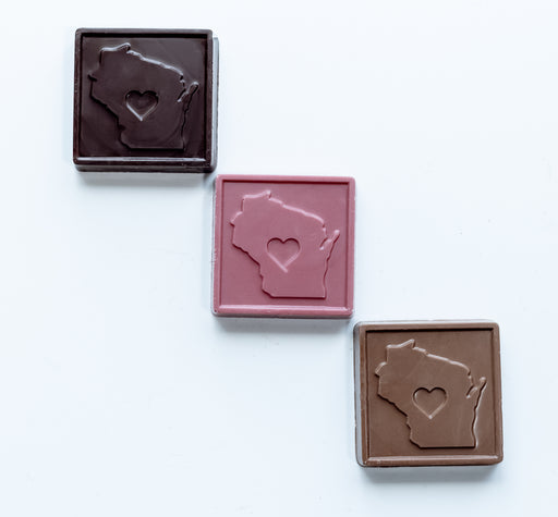 Three chocolate bars with Wisconsin-shaped cutouts on a white background