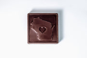 Chocolate bar with a heart-shaped cutout in the shape of Wisconsin on a white background