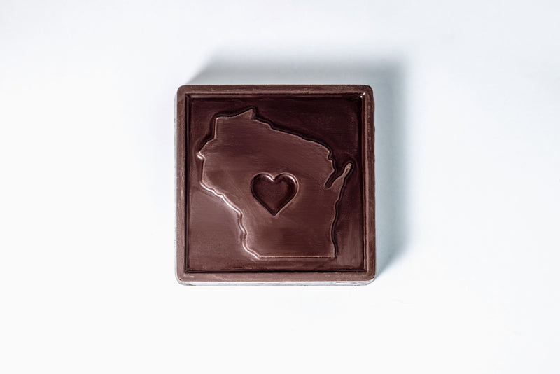 Chocolate bar with a heart-shaped cutout in the shape of Wisconsin on a white background