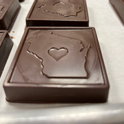 A chocolate bar with a molded design of the state of Wisconsin with a heart shape in the center, made from rich, smooth Belgian chocolate.