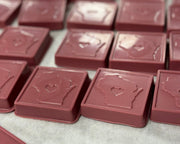 A photo of a chocolate bar with the shape of Wisconsin state and a heart cut-out in the center, indicating a tribute to the state.