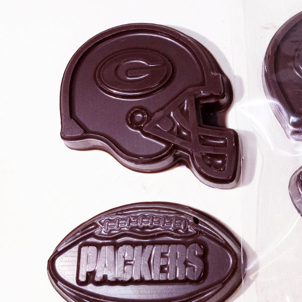 Two chocolate pieces shaped like a football and a helmet with the Green Bay Packers logo on them.